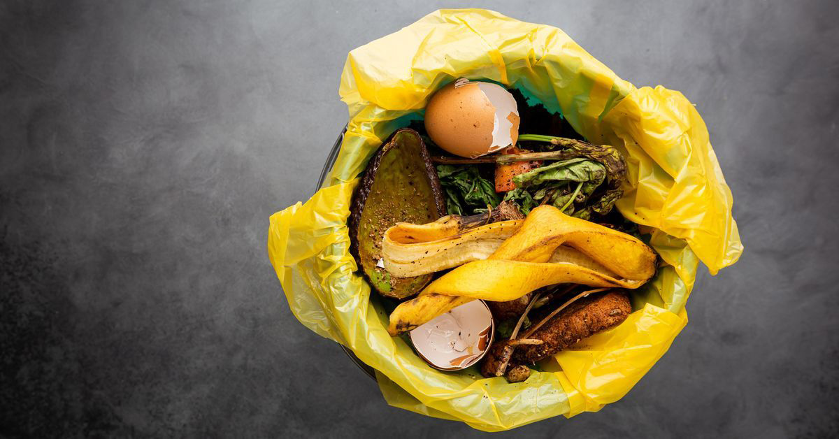 Organic food wastes in a bucket, shot from above. Zero waste, recycle, waste sorting concept - top view of peels and leftovers of fruit and vegetables